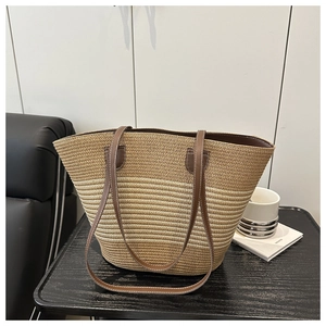 Close-up of woven straw tote bag featuring natural texture and brown leather shoulder straps