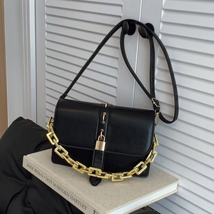 Sac bandoulière noir moderne avec chaîne dorée et boucle sur fond artistique blanc