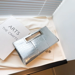 Silver crocodile pattern clutch bag with rectangular metal handle on a minimalist background
