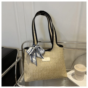Detail of summer woven tote with black leather straps and decorative Paris silk scarf