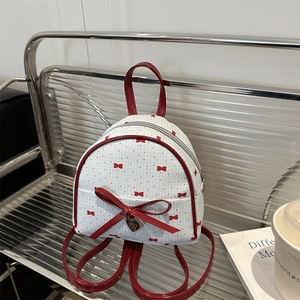 Fashionable mini backpack with red polka dots, heart pendant and large bow detail