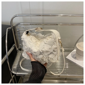 Détail du sac à main blanc avec roses en relief 3D et boucles dorées élégantes