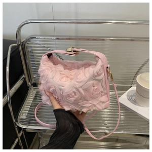 Détail rapproché du sac à bandoulière rose clair avec décorations florales roses en mesh