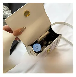 Top-down view of white crossbody bag interior showing storage space for phone and makeup