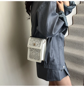 Detailed side view of mini bucket bag with flower lock and floral embossed texture