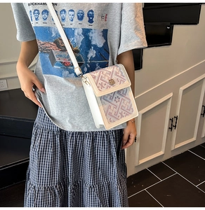 Détail du sac seau en PU blanc avec motifs roses et fermoir doré en forme de pétale
