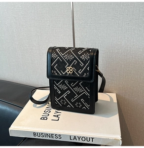 Close-up of Chinese style embroidered crossbody bag with floral texture and clover buckle