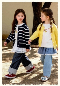 Photo de filles portant des cardigans en maille torsadée et jeans patchwork au soleil