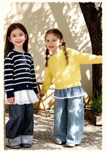 Détail de gilets tricotés pour filles avec ourlets plissés et jeans larges