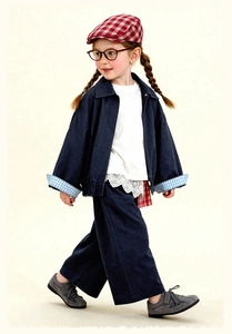 Detail van vintage geruite baret en blauwe casual kinderjas met kanten kraag detail