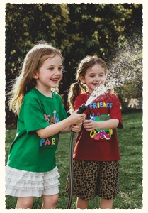 Detalle de camisetas de verano para niñas con estampados de dibujos en el césped