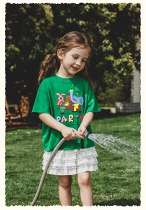 Detalle de camiseta verde vibrante y falda de encaje blanco para juegos de verano al aire