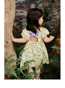Détail d'une robe fleurie pour fille avec bretelles croisées violettes et dos nu
