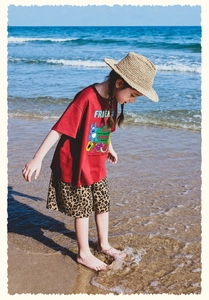 Detalle de camiseta roja para niña con estampado de dibujos y shorts de leopardo