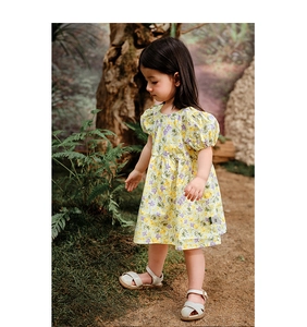 Détail d'une robe d'été fleurie pour fille avec manches bouffantes et motifs violets