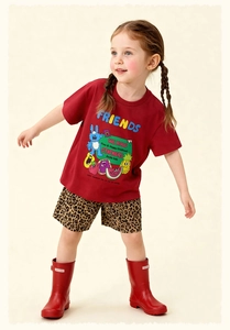 Detalle de camiseta roja de algodón con estampado de dibujos y shorts de leopardo