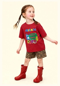 Camiseta roja de niña con monstruo animado, pantalones de leopardo y botas rojas