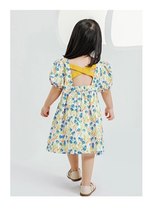 Détail du dos d'une robe fleurie pour fille avec bretelles croisées jaunes et dos nu élégant