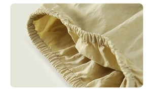 Detail of elastic cuff on beige girl's cotton set with breathable textured fabric