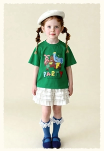 Detalle de camiseta verde para niña con estampado de animales y logotipo de marca