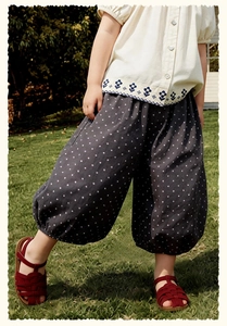 Détail d'une tenue d'été pour enfants avec chemise brodée et pantalon bouffant à pois
