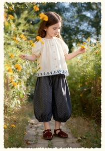 Détails de broderie florale bleue sur chemise en coton et pantalon bouffant à pois