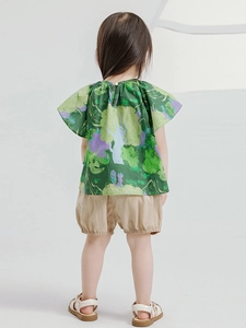 Girls forest style summer set with green printed shirt and beige puffed shorts on model
