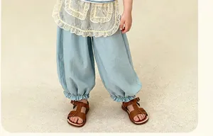 Détail du pantalon bouffant bleu ciel pour fille avec ourlets élastiques et sandales brunes