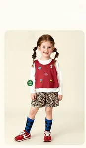 Détail de short léopard pour fille avec gilet rouge brodé et baskets de sport