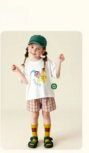 Tenue d'été pour enfant avec t-shirt blanc imprimé, short à carreaux et chaussettes