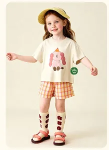 Détail d'ensemble d'été enfant avec t-shirt chiot beige et short à carreaux orange