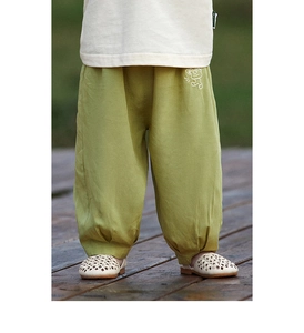 Dettaglio macro dei pantaloni anti-zanzara verde chiaro per bambini con ricamo e polsini