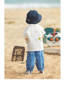 Vista posteriore di un bambino con camicia panda e pantaloni antizanzare blu in spiaggia