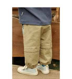 Detail van een duurzame kaki cargobroek met elastische boorden en duidelijke stoftextuur