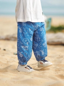 Pantaloni antizanzare celesti per bambini con stampe a fumetti su spiaggia soleggiata