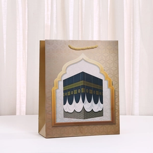 Kraft paper gift bag with golden Kaaba illustration and Middle Eastern arch design