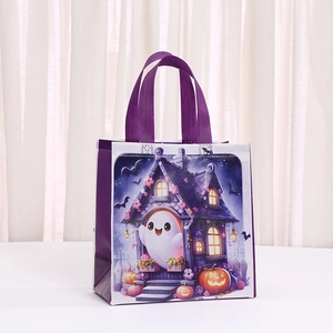 Detail of Halloween non-woven gift bag with ghost and pumpkin prints on white desk