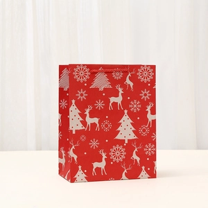 Red Christmas paper gift bag with white reindeer patterns and twisted rope handles