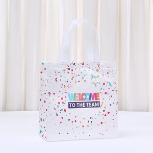 Sac cadeau blanc en non-tissé avec inscription Welcome to the Team et pois colorés