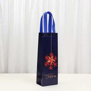 Blue Christmas wine gift bag with red snowflakes and Merry Christmas lettering