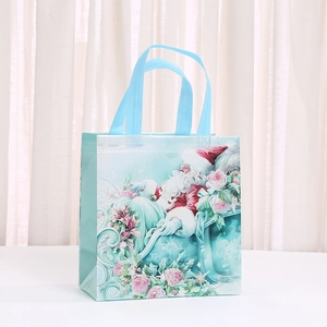 Light blue non-woven Christmas gift bag with Santa Claus and floral holiday patterns