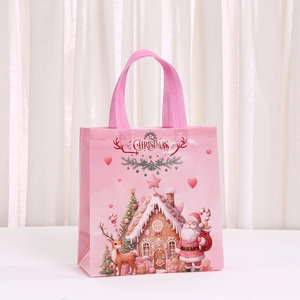 Pink non-woven Christmas gift bag with Santa Claus, gingerbread house, and sturdy handles