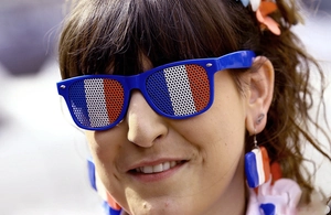 Detail of French flag mesh sunglasses and matching rectangular earrings on a model