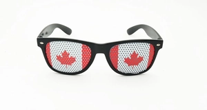 Detail of Canadian flag pattern on lenses of classic black frame party sunglasses