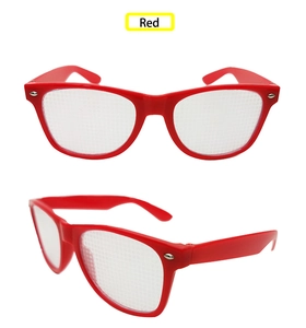 Close-up of red pinhole glasses with dense micro-perforated lenses for party effects