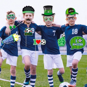Group of young players using soccer party photo props with football goggles and signs