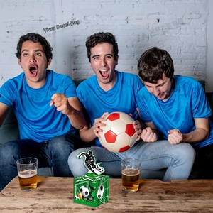 Soccer party money box detail with grass print and athlete topper on wooden table