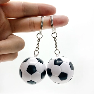 Nahaufnahme von zwei klassischen Schwarz-Weiß-Fußball-Schlüsselanhängern in der Hand