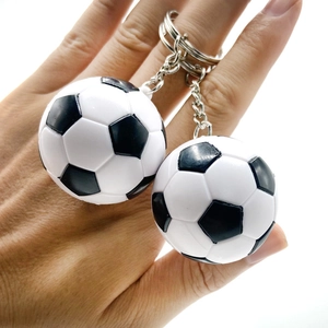 Nahaufnahme von klassischen Fußball-Schlüsselanhängern mit Metallketten in der Hand