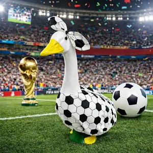 Garden goose ornament in soccer outfit on grass field for World Cup party decor